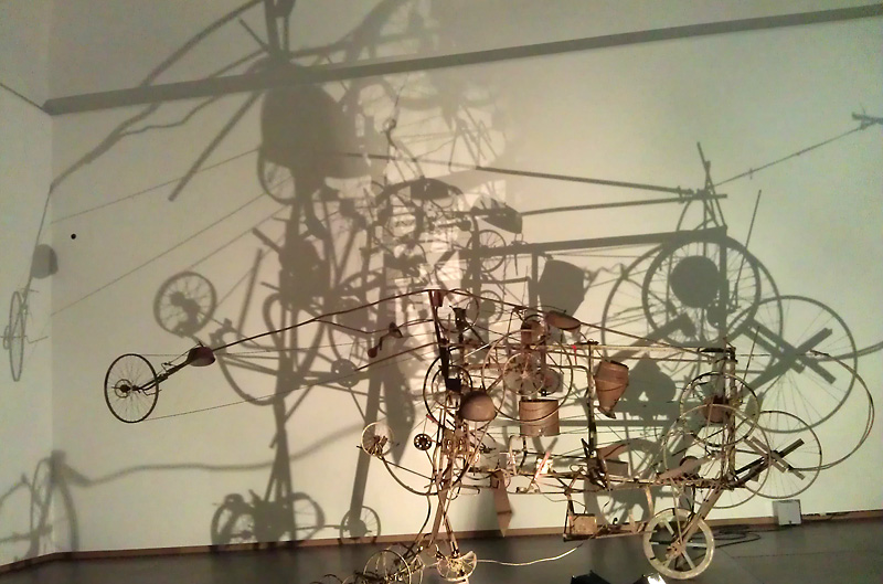 Machine van Tinguely op de tentoonstelling werpt schaduwen. Foto auteur