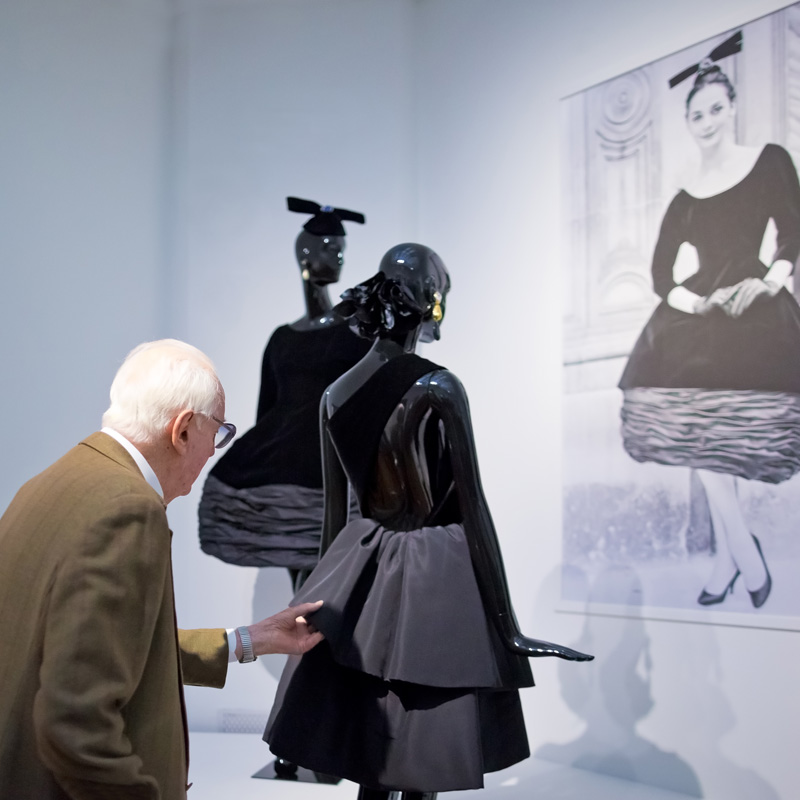 Hubert de Givenchy schikt nog iets aan een van zijn creaties op de tentoonstelling. Foto Maurice Haak, Den Haag Marketing